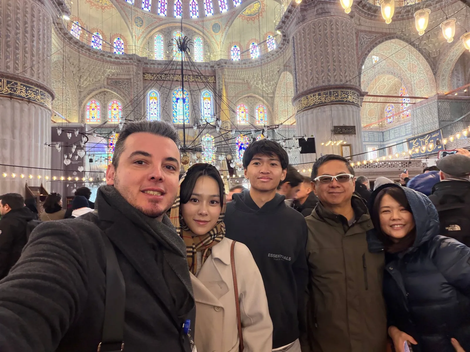 Tour guests inside the Blue Mosque under stained glass windows, Istanbul