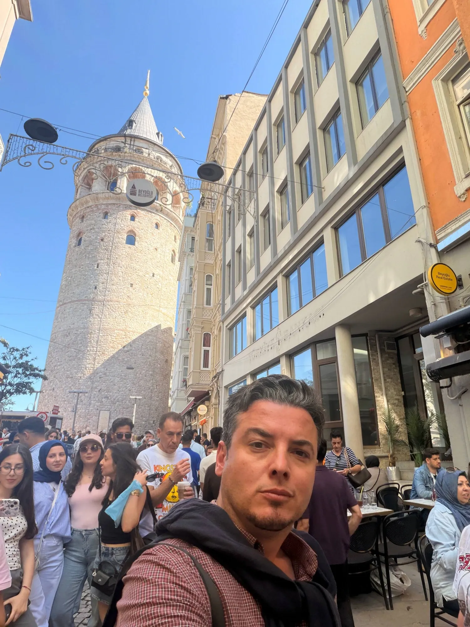 Guide Akın with the Galata Tower rising above the crowds in Beyoğlu, Istanbul